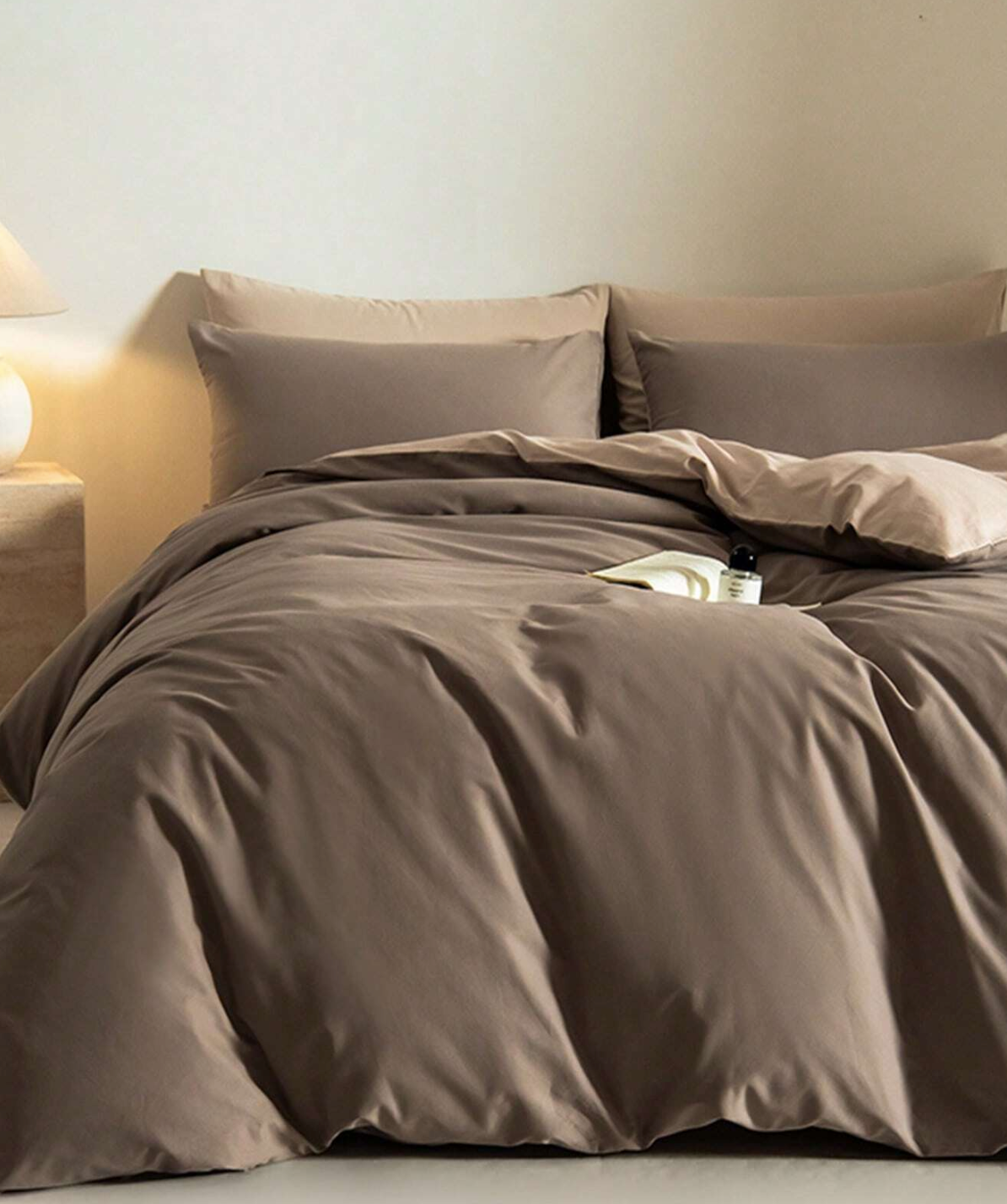 Brown bedding set on a bed with a neutral wall background